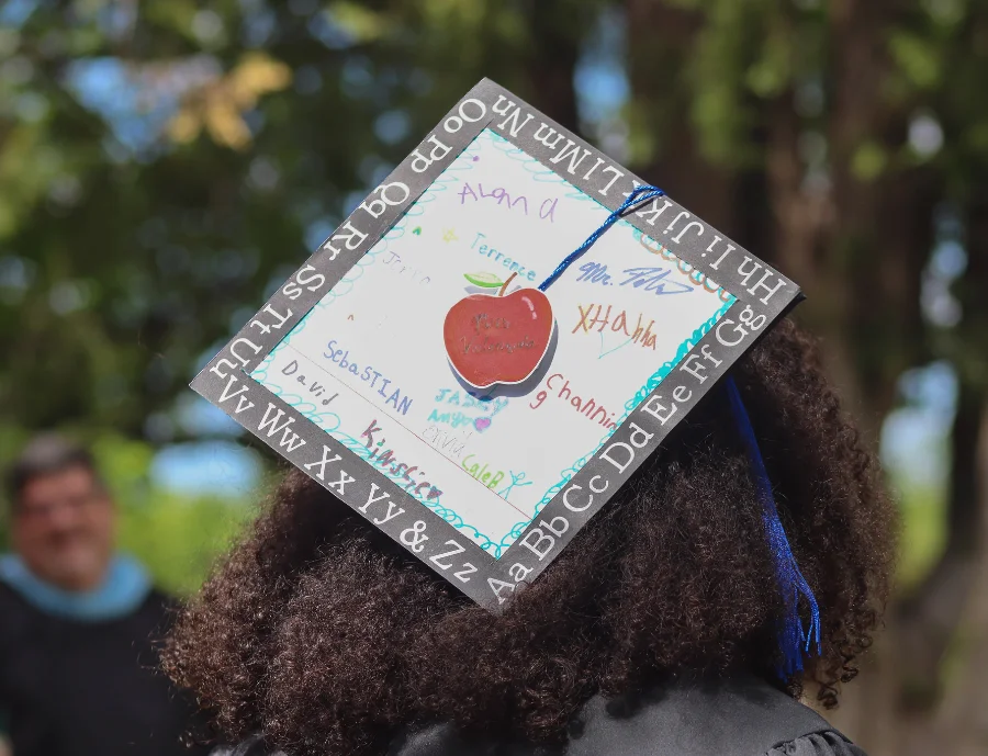 Graduate wearing a decorated mortarboard at Central Christian College of Kansas commencement, symbolizing academic achievement and community.