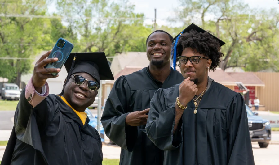 Graduating students taking a selfie in caps and gowns at Central Christian College, celebrating commencement, friendship, and student achievement.