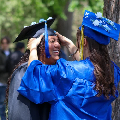 Graduates celebrating commencement on campus at a Christian College, sharing a joyful moment that reflects faith, achievement, and community.