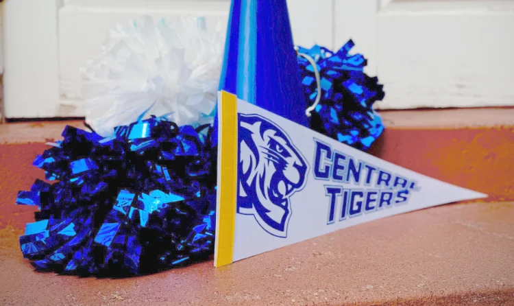 Central Tigers pennant and blue pom-poms displayed on campus steps at a Christian College, symbolizing school spirit and student pride.