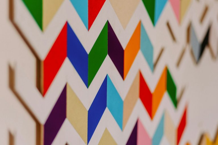 a close up of a colorful wall with a clock